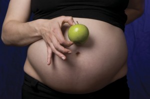 Gravid kvinna med ett äpple